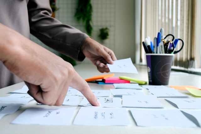 Persona señalando documentos en escritorio, representando la personalización de procesos con B1UP de Boyum IT